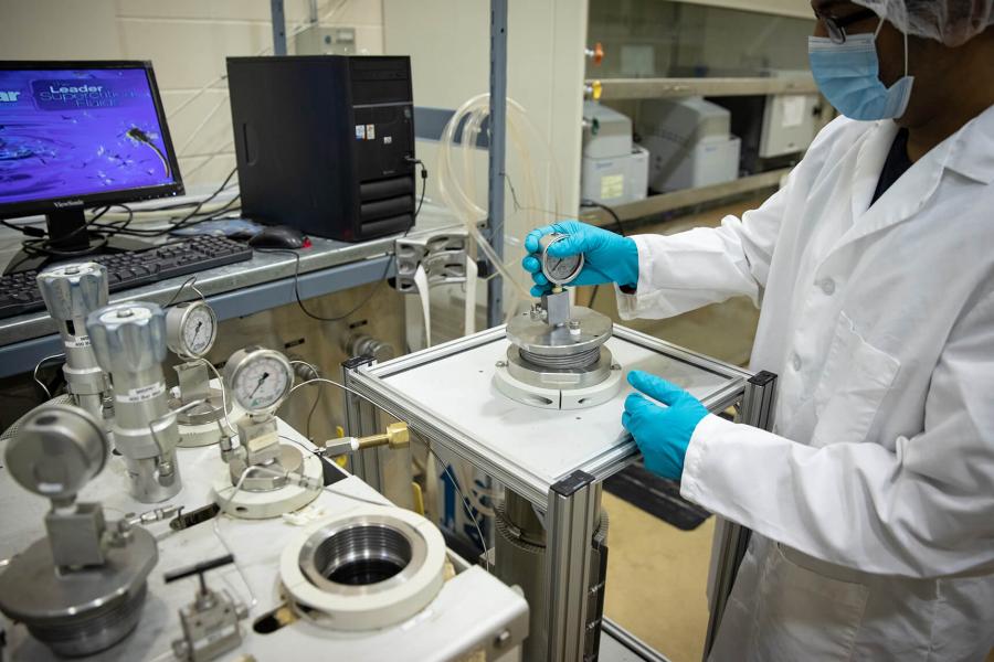 A technician opens a piece of equipment for super critical fluid extraction.